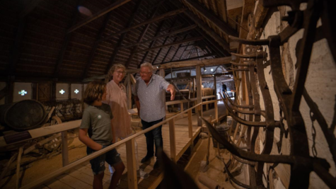 En familie kigger på en udstilling i en lade hos Glud Museum