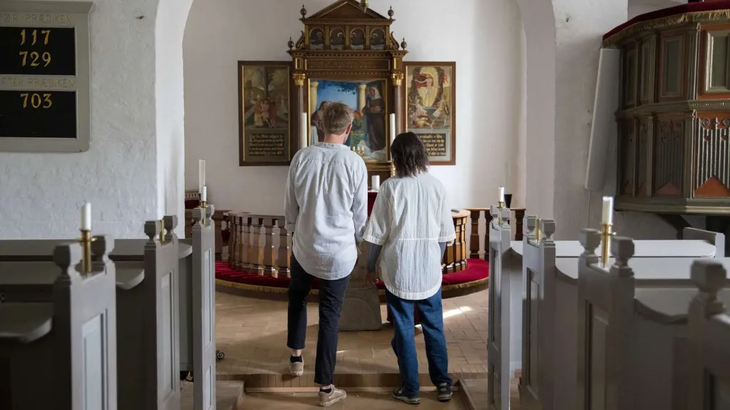 A couple looking at the altarpiece in Endelave Church