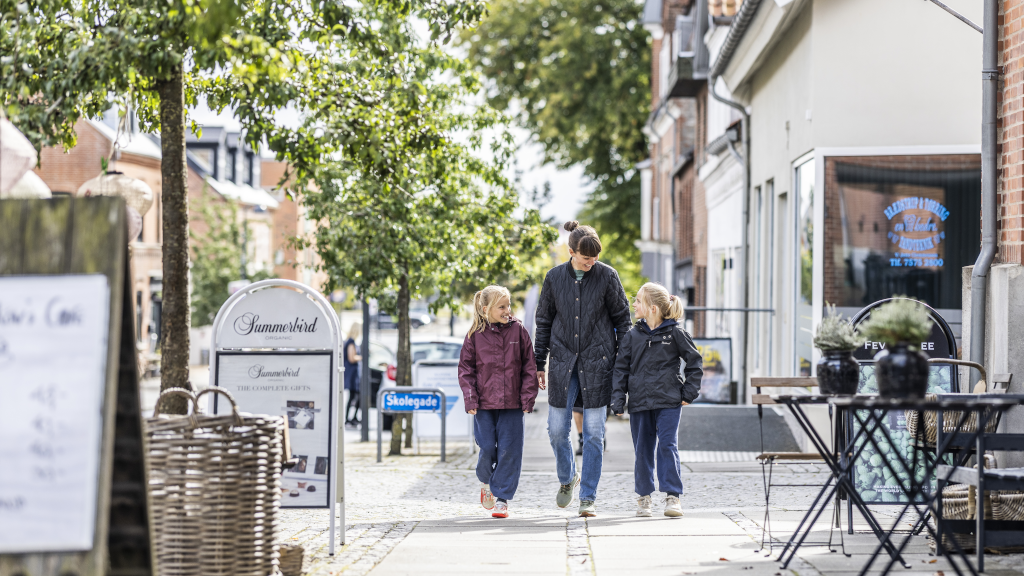 A mother and her two daughters are taking a walk through the center of Brædstrup