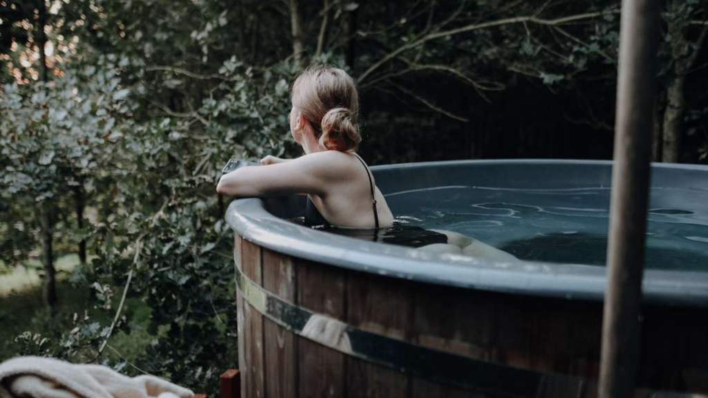 A woman looks out at the trees from a wilderness bath at BØGEBJERG in Østbirk