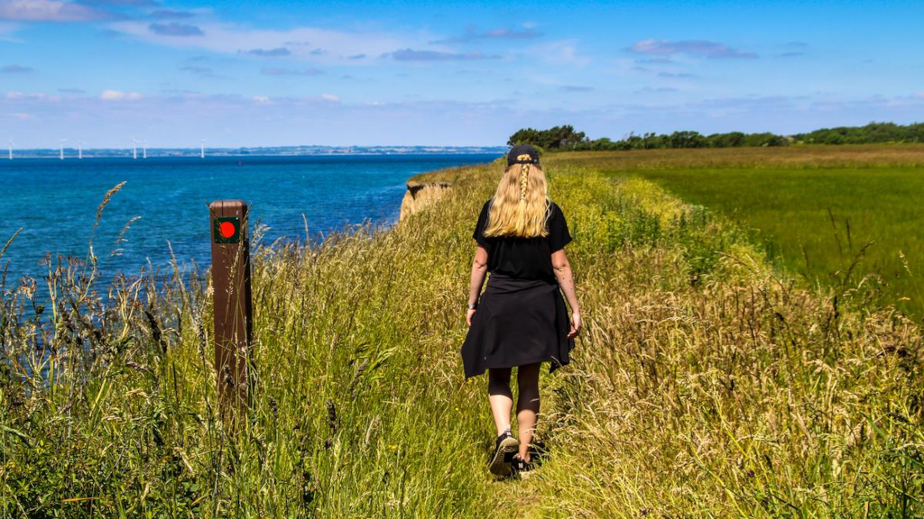 A woman walks along a grassy path at the top of Sønderklint on Tunø