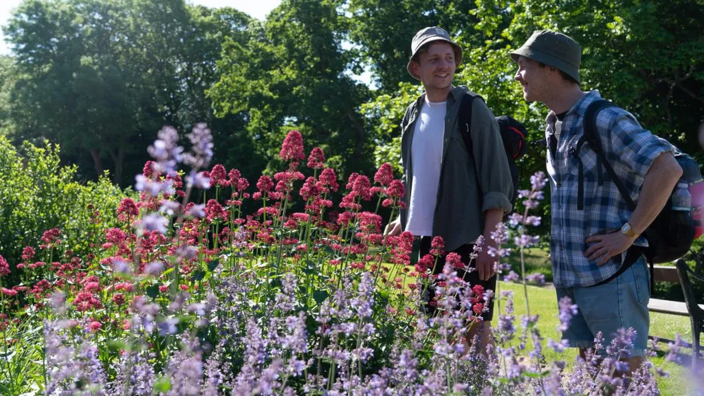 Two men are looking at flowers in Palsgaard Castle Park