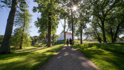 Mænd går på sti i park i retning af Palsgaard Slot