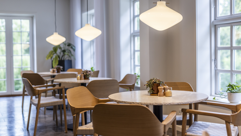 Round tables and chairs by the window in Restaurant Bygholm