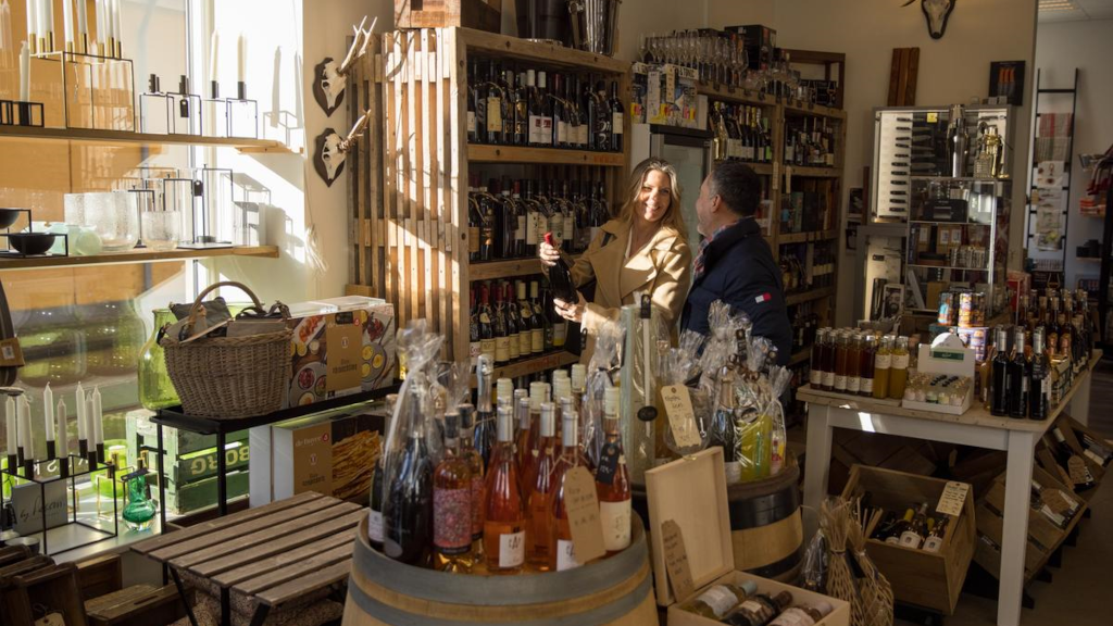 A couple is looking at wine bottles in the store Fru Skov