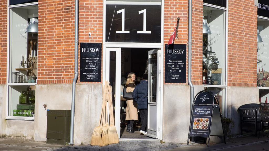 A couple stands at the entrance of the store Fru Skov in Brædstrup
