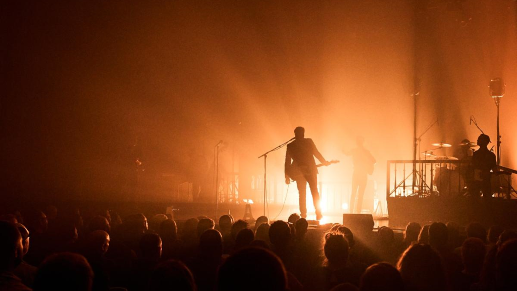 Kellermensch performs on stage at Horsens Ny Teater, surrounded by orange lights