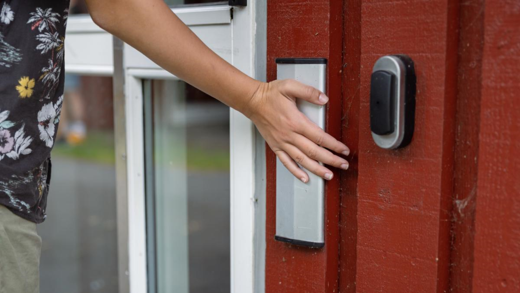 A hand on a door handle at the entrance to a holiday cottage at Hou Søsportcenter