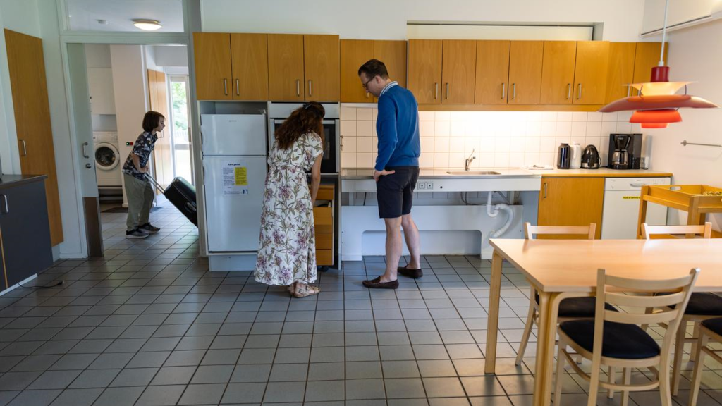 A family is standing in a kitchen in a holiday cottage at Hou Søsportcenter