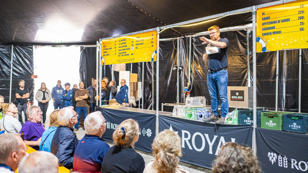 Mand står på bardisk og taler til publikum til Juelsminde Havnefest