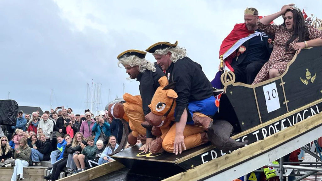 Vogn med mænd i fjollede kostumer ryger i havnebassinet til Hou Havnefest
