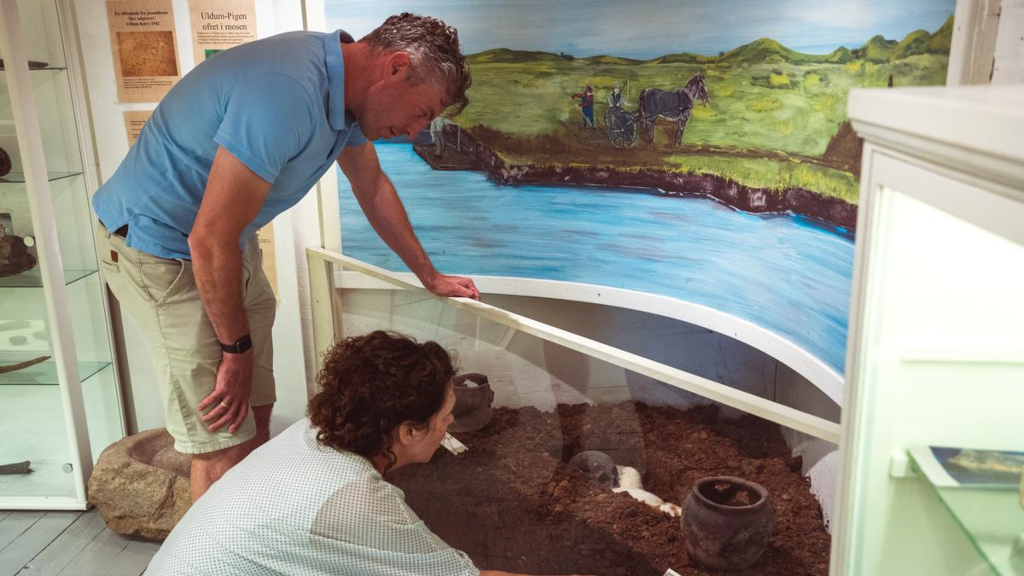 A couple is looking at the Uldum Girl in the exhibition at Uldum Mill Museum