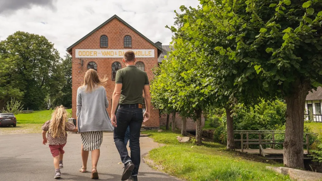 En familie går mod vand- og dampmøllen på Odder Museum