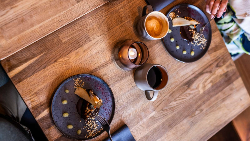 A table viewed from above with arranged cake and coffee