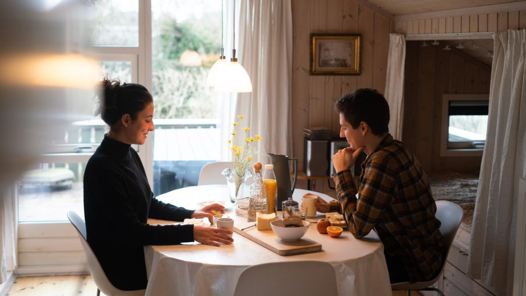 A couple is sitting at a dining table in a summer house