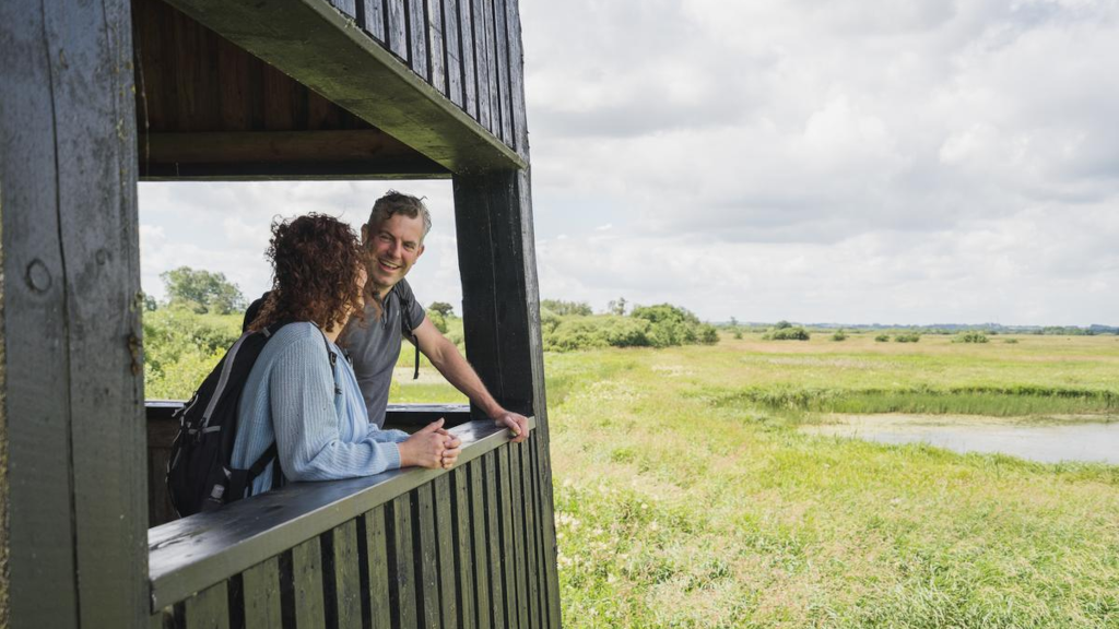 A couple is looking out from the bird tower at Uldum Kær