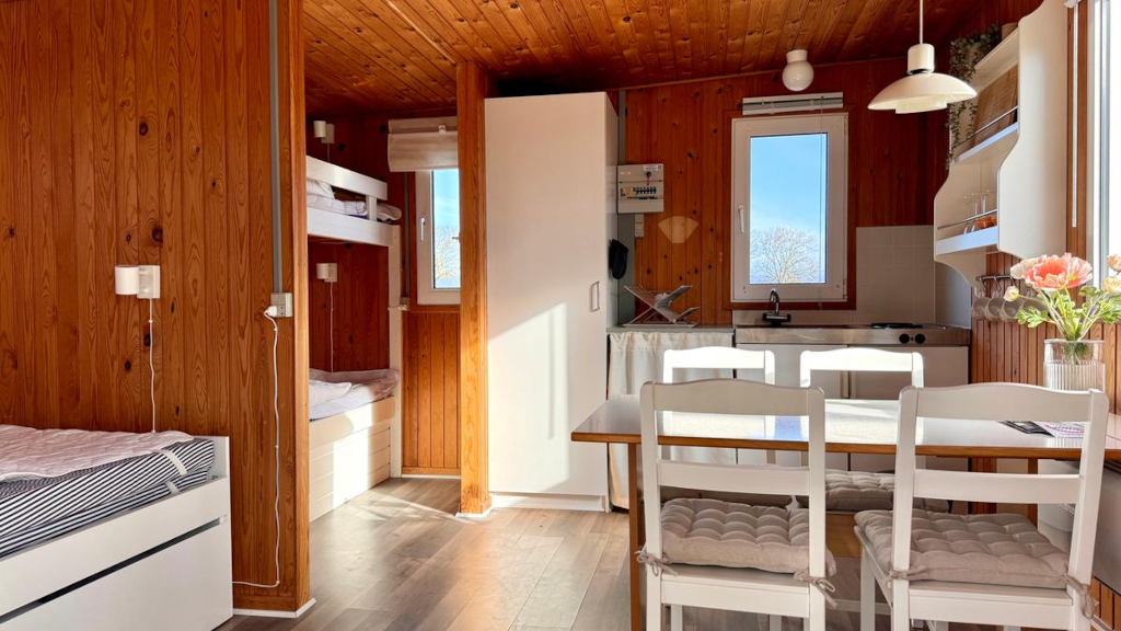A four-person cabin with a kitchen and dining area at Campingpladsen Endelave