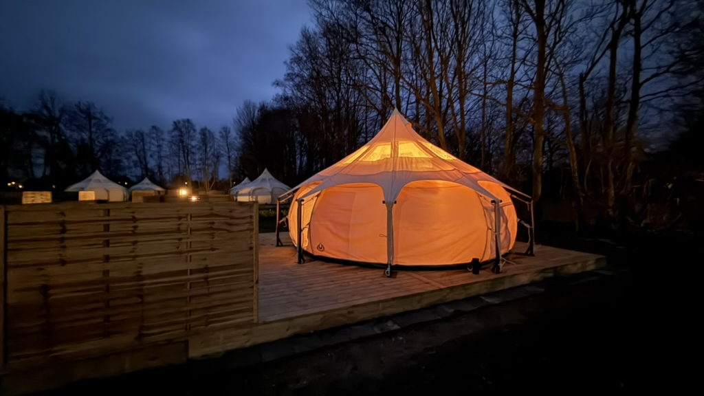 Illuminated glamping tent at Campingpladsen Endelave at night