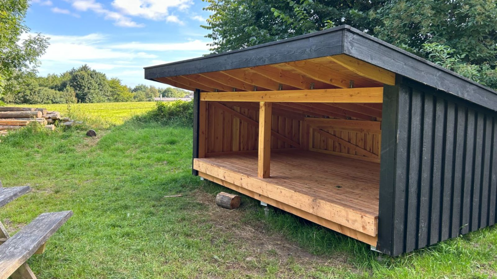 Black-painted shelter by a field
