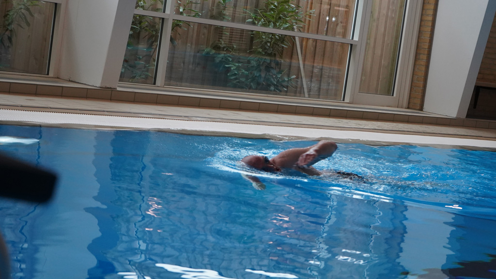 A man is swimming in a pool in a swimming hall at Hedensted Centre