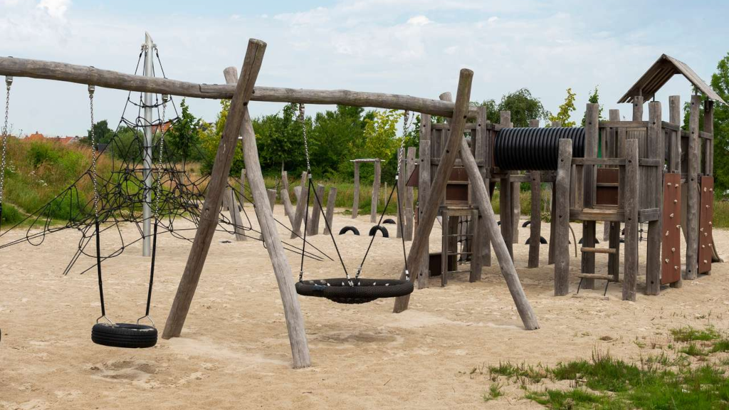 Gyngestativ og klatretårn på legepladsen i Bakkelunden