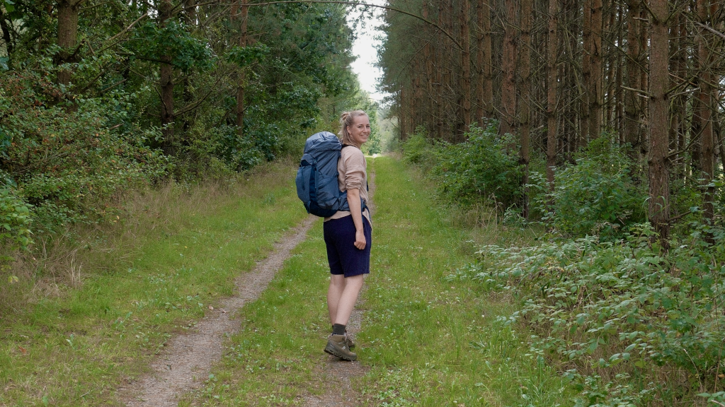 Kvinde går gennem skov på GudenåStien