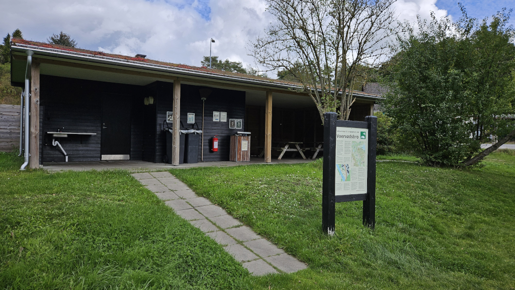 Toiletbygning og skilt ved Voervadsbro Teltplads