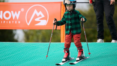 Lille dreng på ski på skibakken hos BGI Snowsport Arena