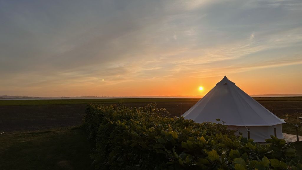 Glampingtelt ses i solnedgangen