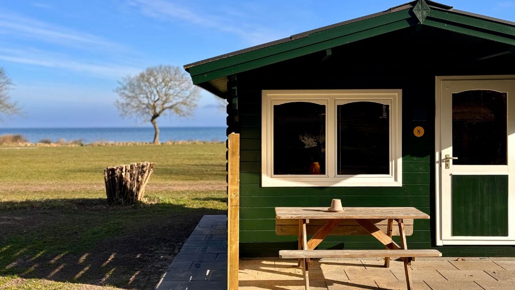 Hytte nr. 8 set udefra med havet som baggrund