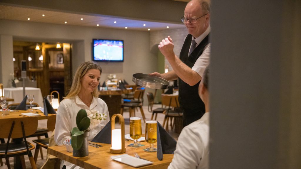 Restaurant Det Gode Selskab på Pejsegården, hvor et par sidder et bord i restauranten.