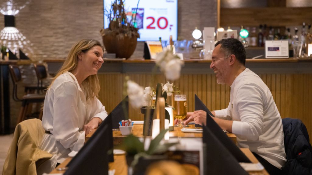 Restaurant Det Gode Selskab på Pejsegården, hvor et par sidder et bord i restauranten.