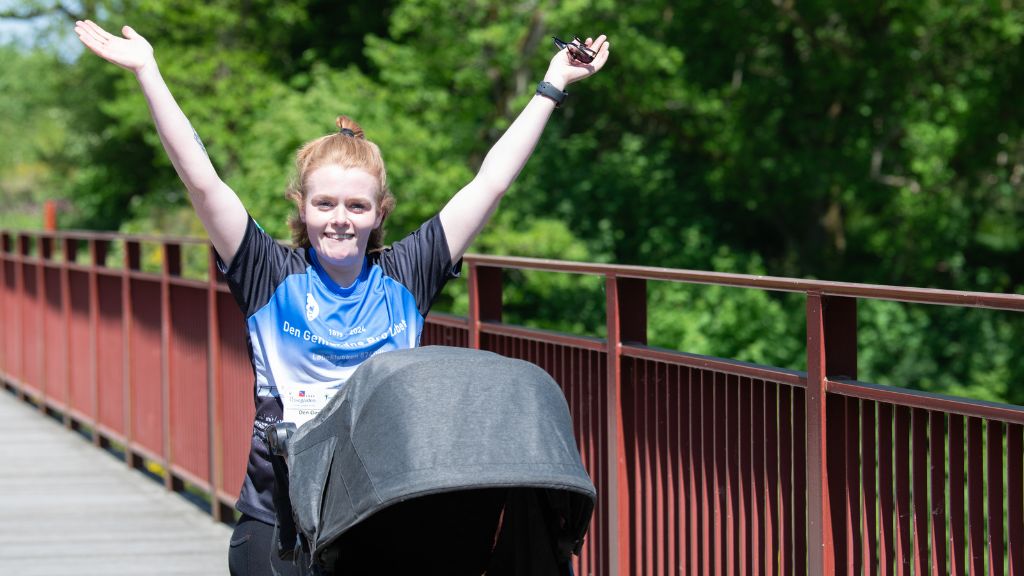 Frau mit Kinderwagen, die am Den Genfundne Bro-Lauf teilgenommen hat