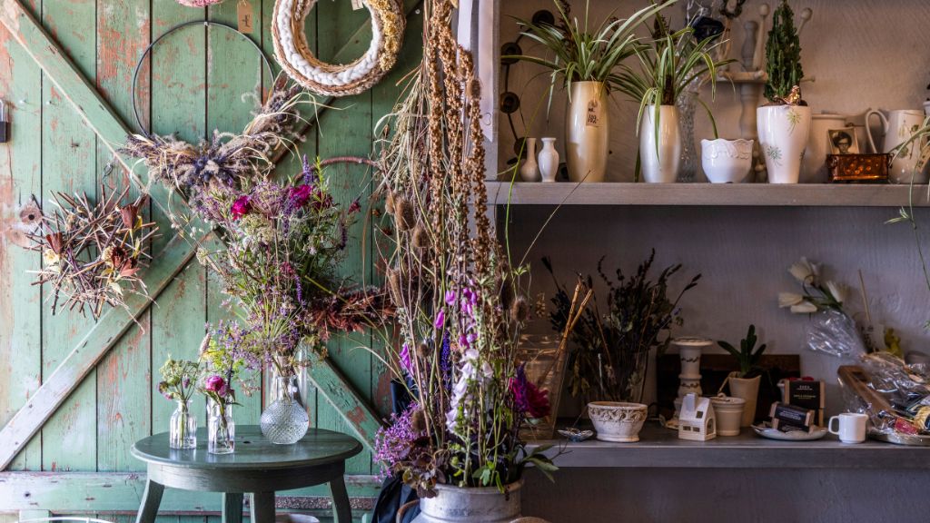 Tinnetgaard Farm Shop with beautiful decorative items displayed on the shelves, including flower wreaths, vases, and fresh and dried flowers.