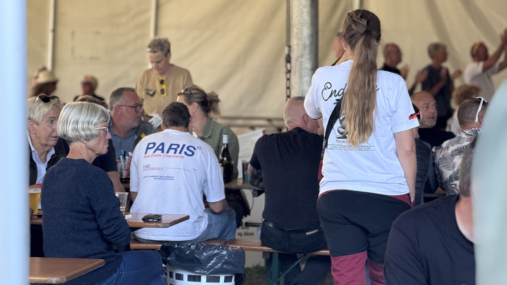 Festivalgæster ved borde i festivaltelt til Festivalen Endelave