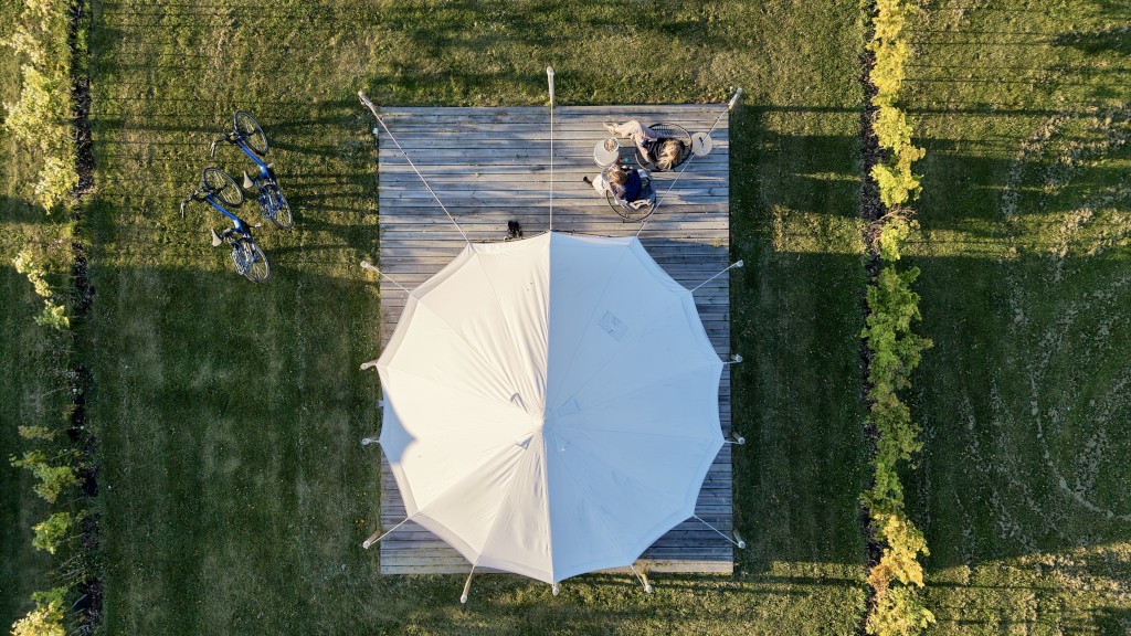 Dronefoto af glamping-telt med et par på terrassen