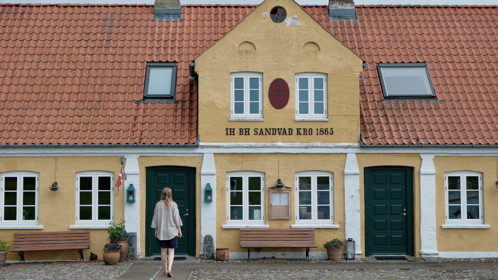 Kvinde går mod indgangen af Sandvad Kro