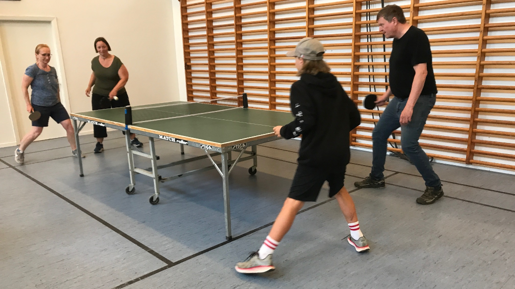 Familie spiller bordtennis i hal