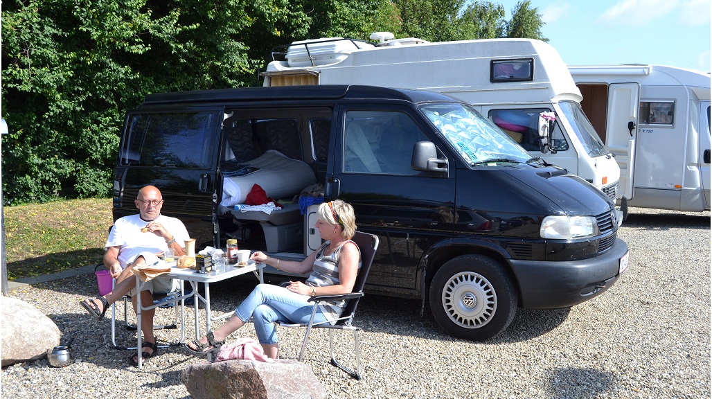 A couple is relaxing at the camper van site at Juelsminde Harbour