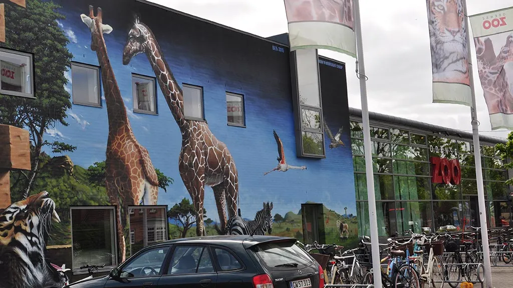 Vægmaleri af giraffer og andre dyr på Odense Zoos facade