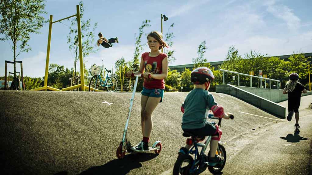 Children with scooters and a bicycle at Rabalder Parken in Musicon