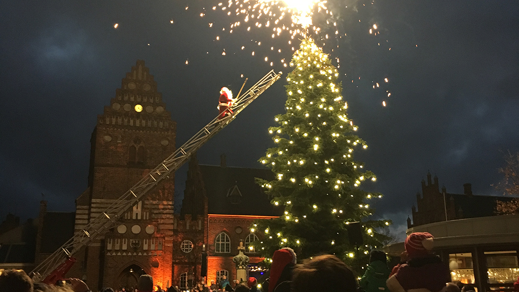 Santa Claus on a ladder beside an illuminated Christmas tree on Stændertorvet in Roskilde