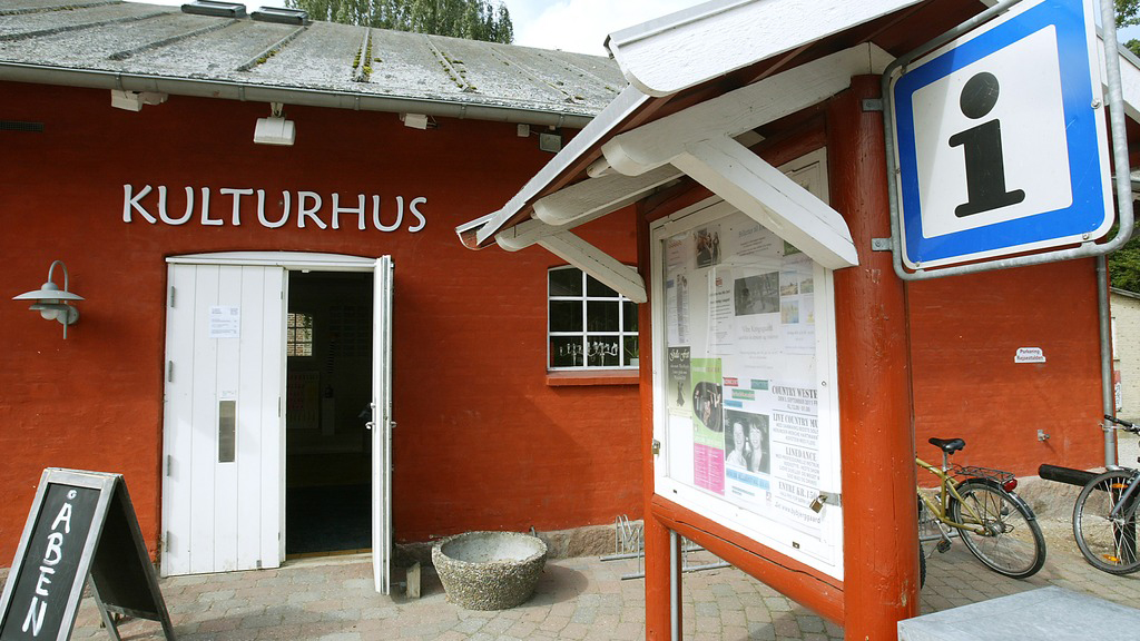 Red façade with cultural centre and information signs at Rejsestalden