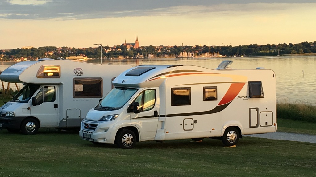 Wohnmobile auf Roskilde Camping mit Fjord und Dom zu Roskilde im Hintergrund.