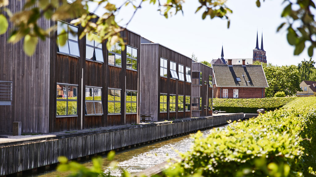 The timber-clad Danhostel Roskilde building beside the water