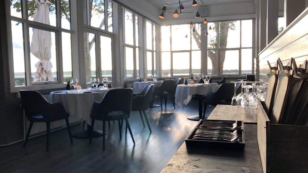 Dækkede borde ved store vinduer med udsigt til Roskilde Fjord på Restaurant Vigen.