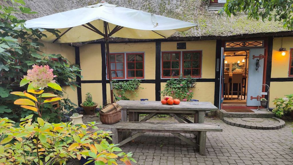 Picknicktisch vor einem Fachwerkgebäude bei Chefs Cottage and Garden Café