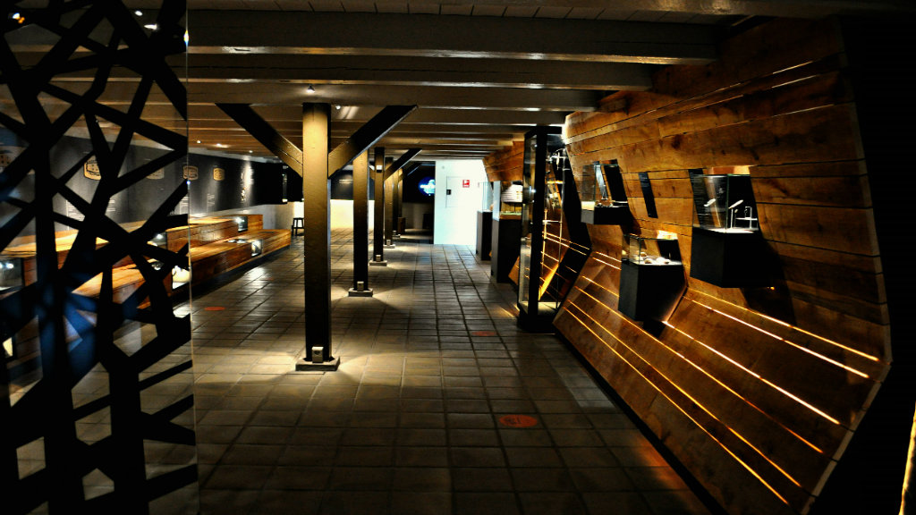Exhibition room with wooden walls and display cases at Lejre Museum.