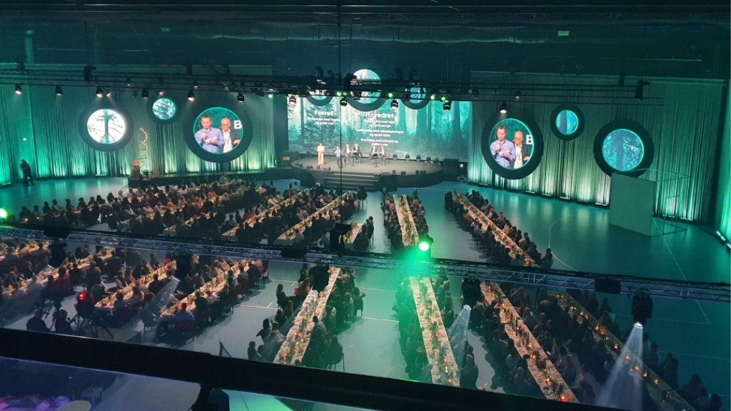 Banquet event at Roskilde Kongrescenter with long tables and stage.