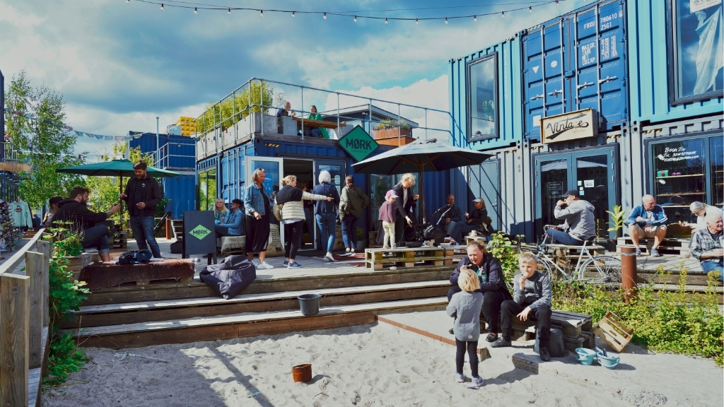 Vibrant urban space at Musicon with containers, café and people enjoying themselves.